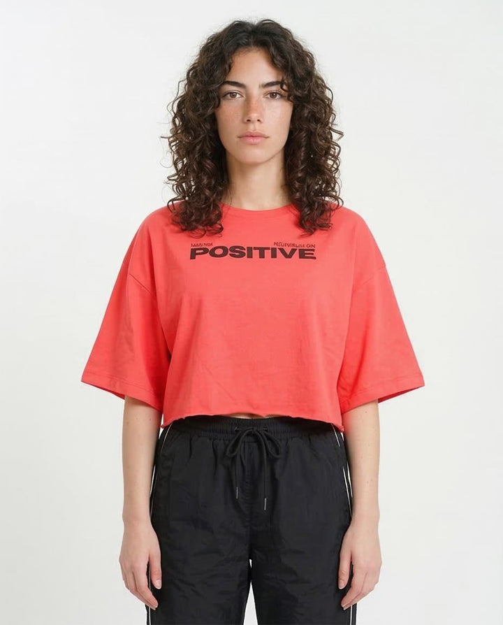 Person wearing a red t-shirt with 'POSITIVE' text on a white background