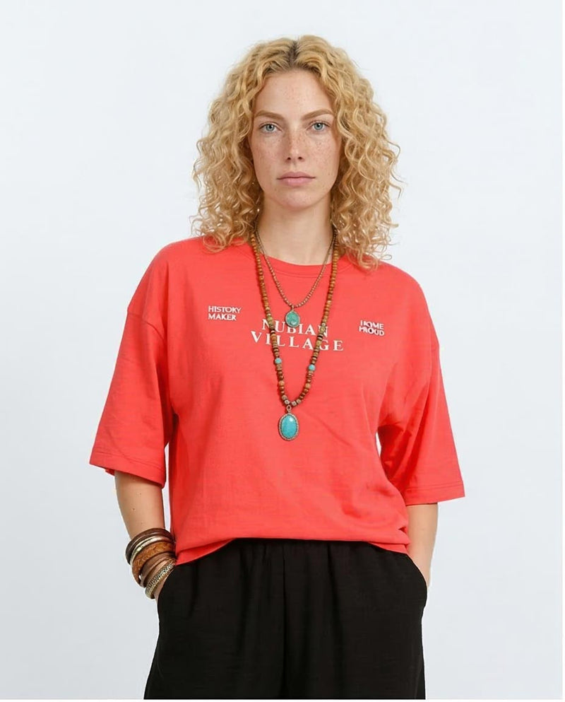 Woman wearing a red t-shirt with text, standing against a plain background