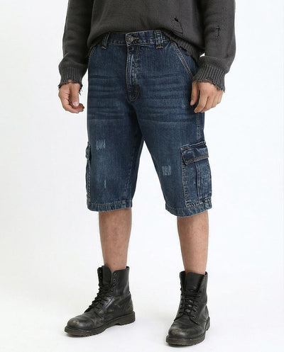 Person wearing blue cargo shorts and black boots on a white background