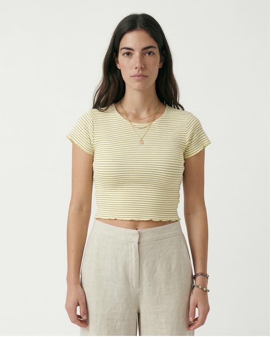 Woman wearing a yellow striped shirt and beige pants on a white background