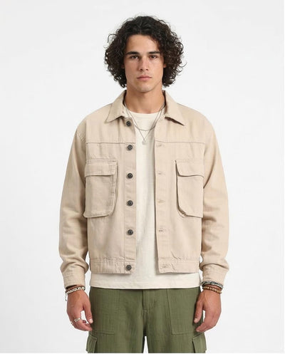 Man wearing a beige jacket with a plain background