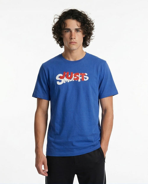 Man wearing a blue t-shirt with 'JUST SMILES' text on a white background