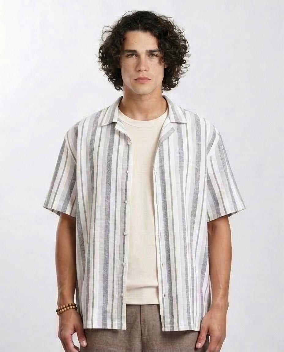 Man wearing a striped shirt over a plain shirt on a white background