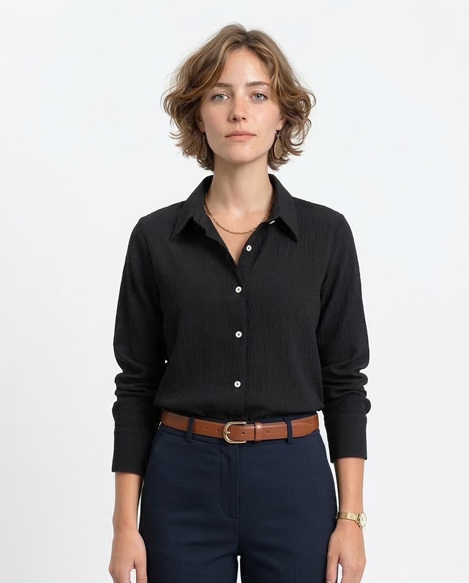 Woman wearing a black shirt and navy pants on a white background