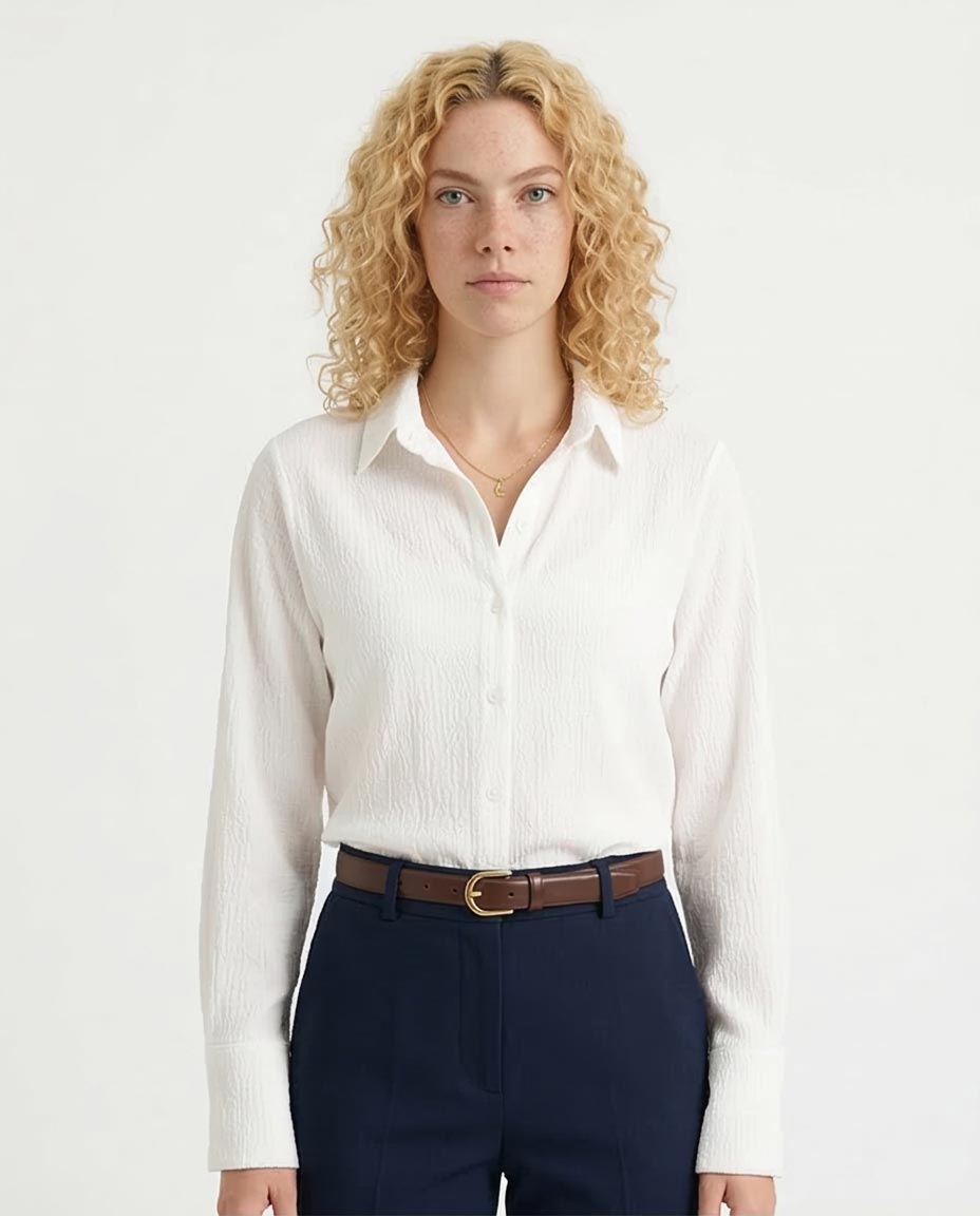 Woman wearing a white shirt and navy pants on a white background