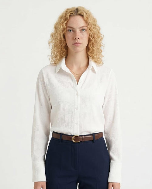 Woman wearing a white shirt and navy pants on a white background