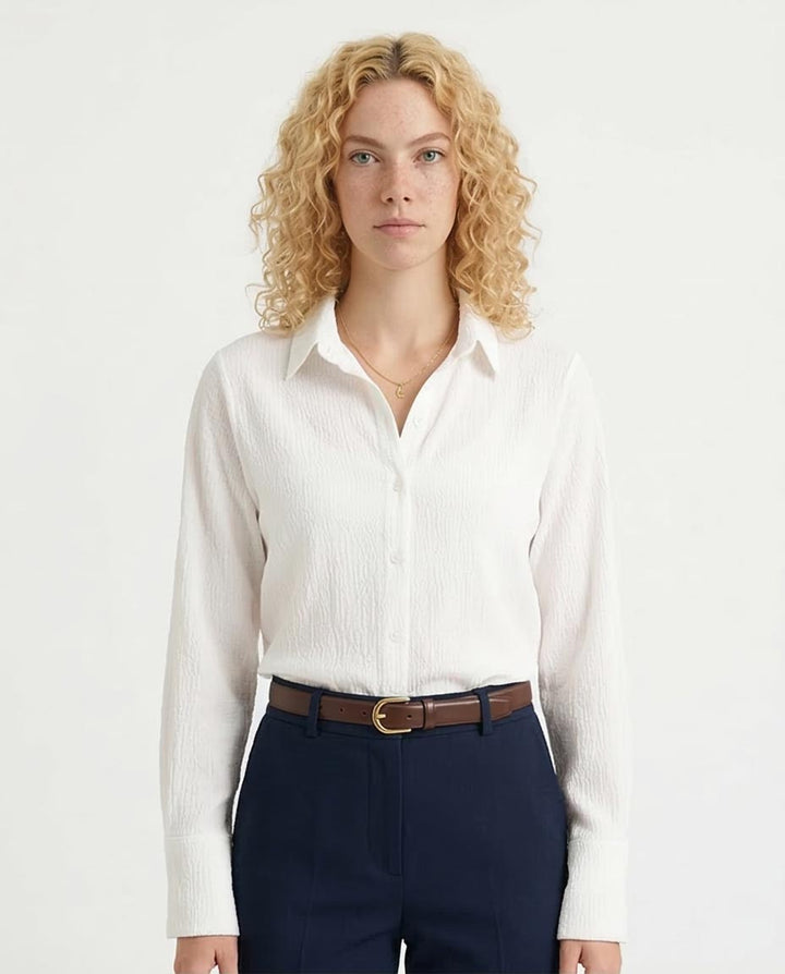Woman wearing a white shirt and navy pants on a white background