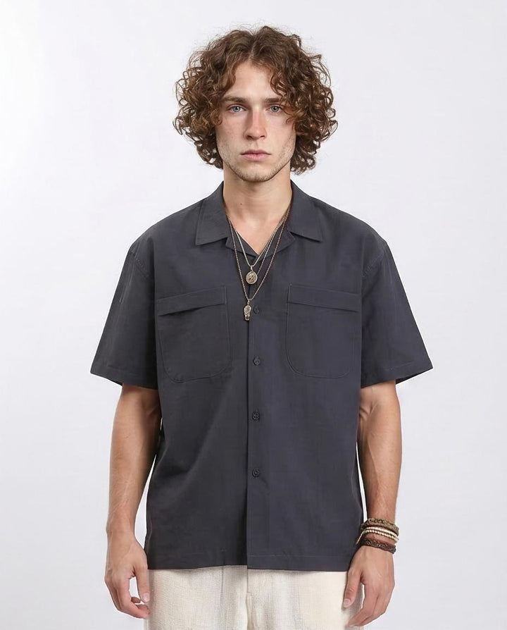 Man wearing a dark gray short-sleeve shirt on a white background
