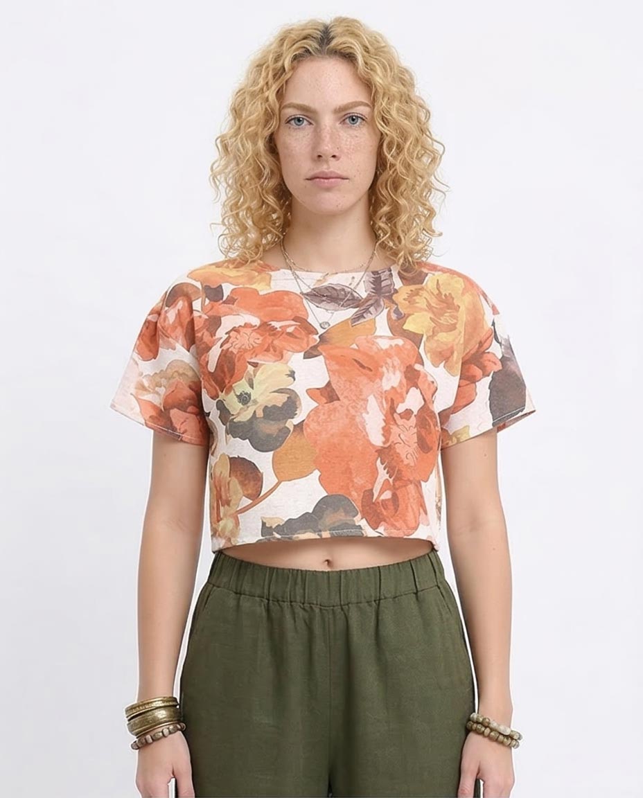Woman wearing a floral top and green pants on a white background