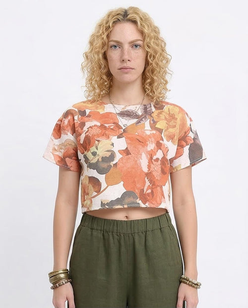 Woman wearing a floral top and green pants on a white background