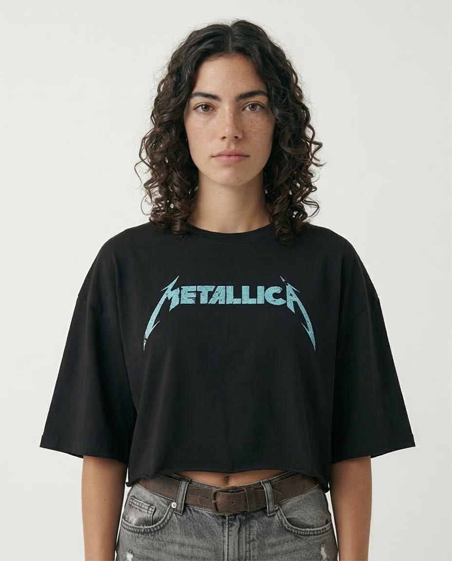 Woman wearing a black t-shirt with Metallica logo on a plain background