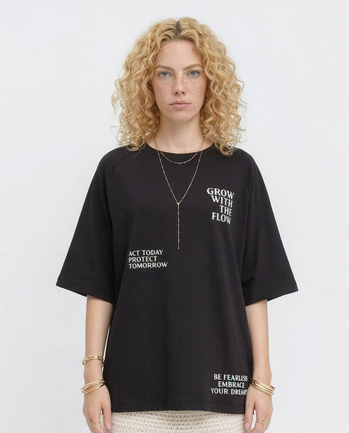 Woman wearing a black t-shirt with motivational phrases on a white background