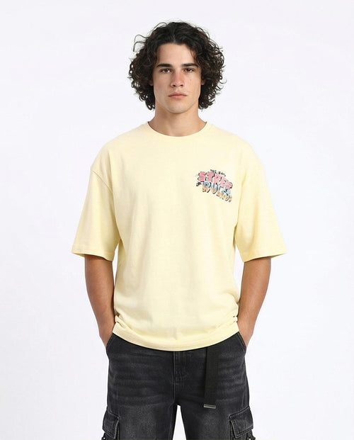 Person wearing a light yellow t-shirt with a colorful graphic on a white background