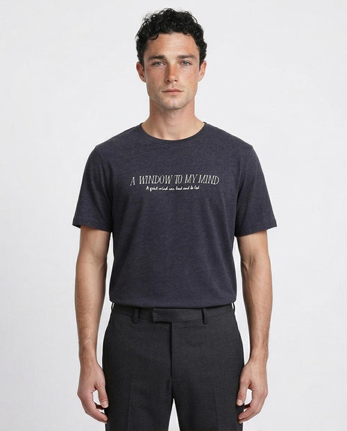 Man wearing a dark gray t-shirt with text on a white background