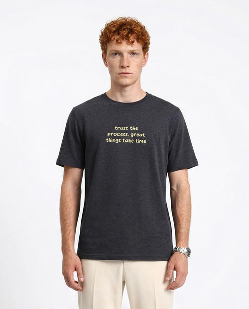 Man wearing a black t-shirt with text on a white background