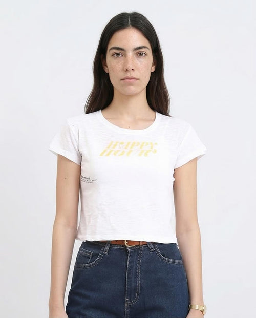Woman wearing a white t-shirt with yellow text and blue jeans on a plain background