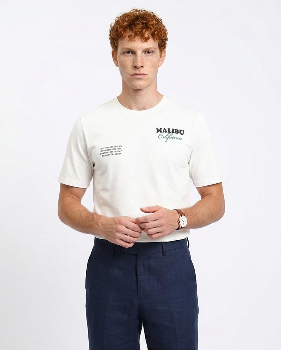 Man wearing a white t-shirt with 'Malibu California' text on a plain background