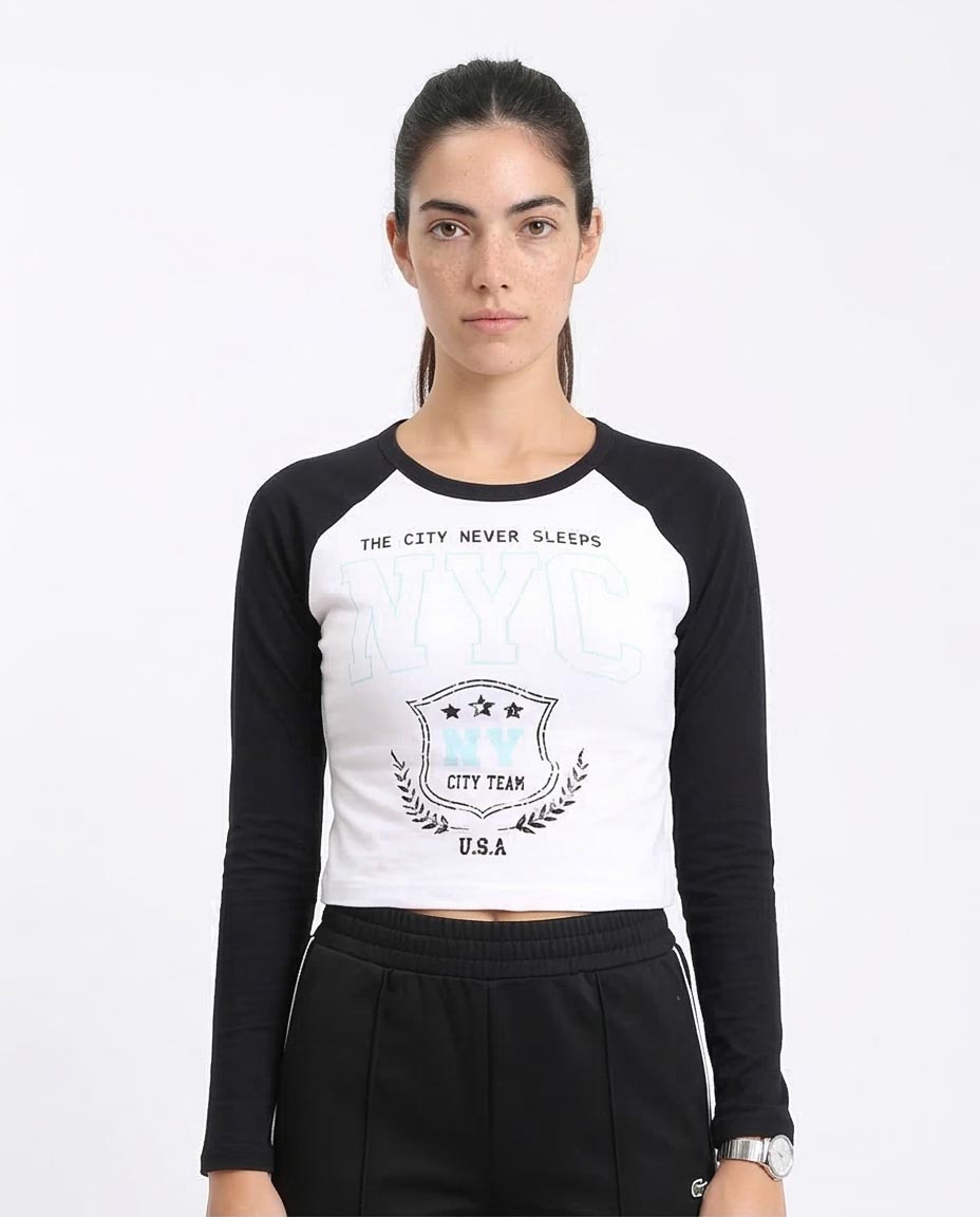 Woman wearing a black and white long-sleeve crop top with text and logo on a white background
