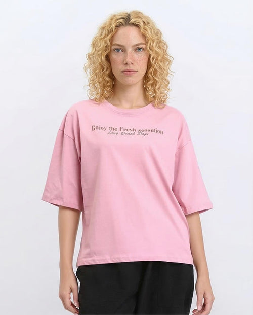 Woman wearing a pink t-shirt with text on a white background