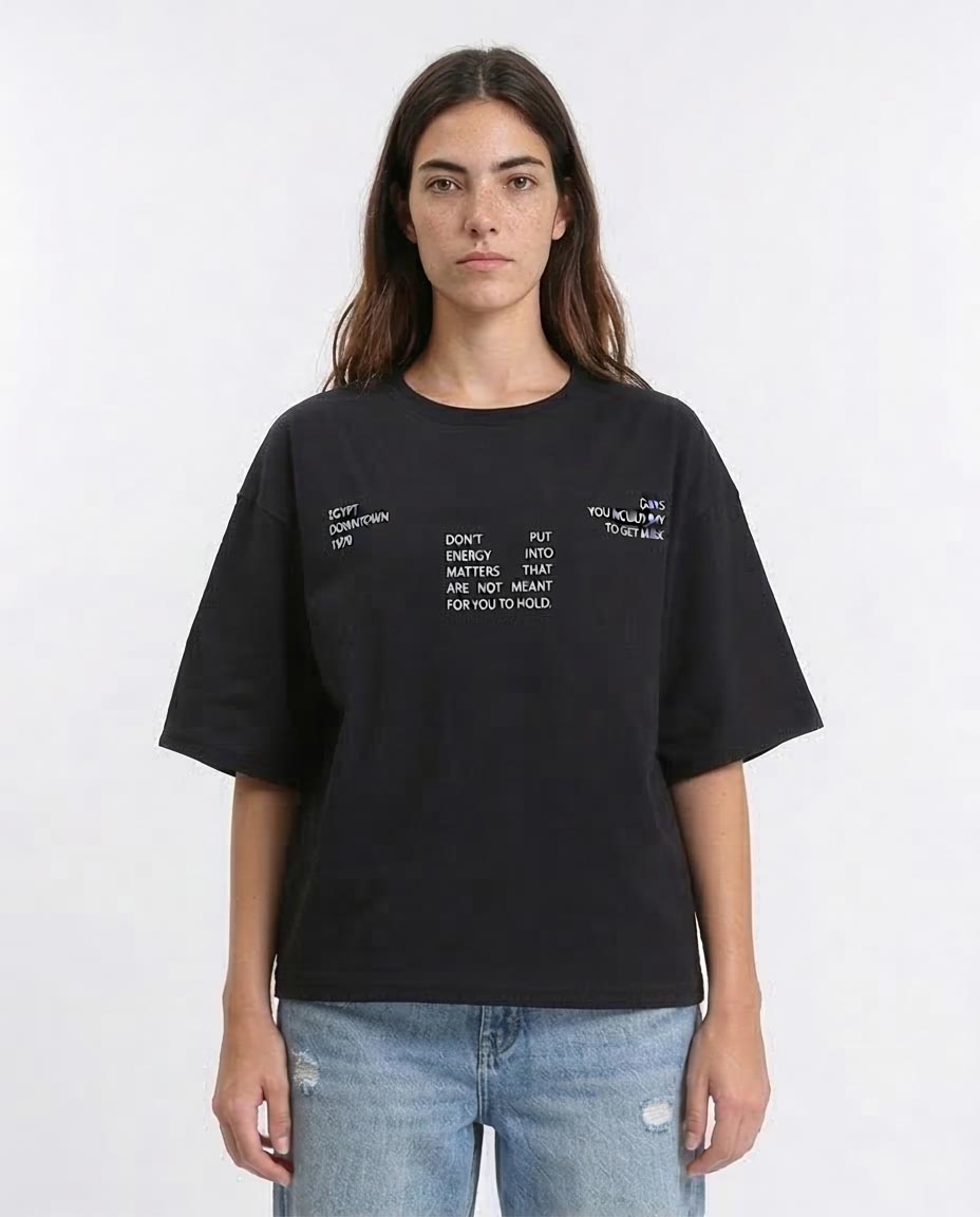Woman wearing a black t-shirt with text on a white background