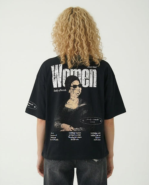 Woman wearing a black t-shirt with a graphic design of Umm Kulthum on the back, featuring text and a stylized portrait.