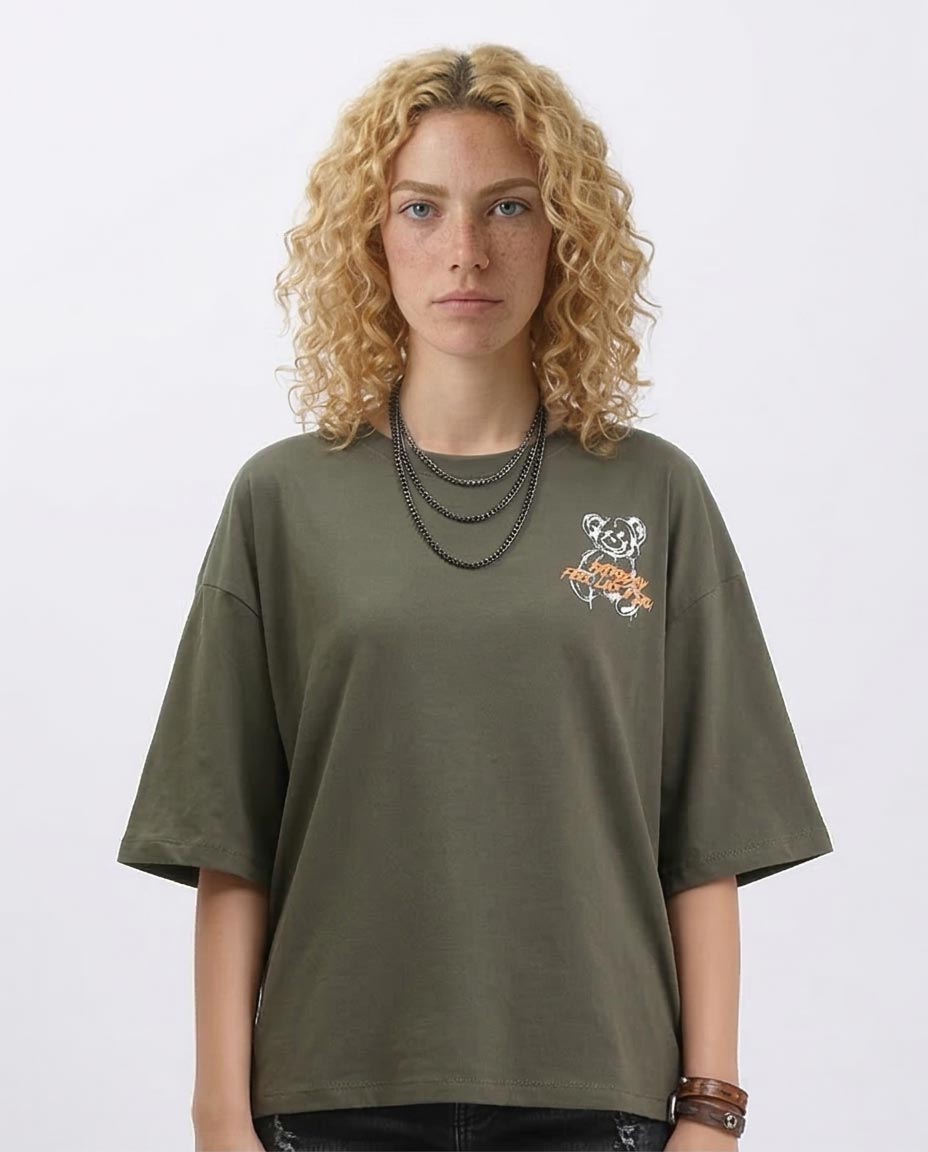 Person wearing an olive green t-shirt with a small graphic on a plain background