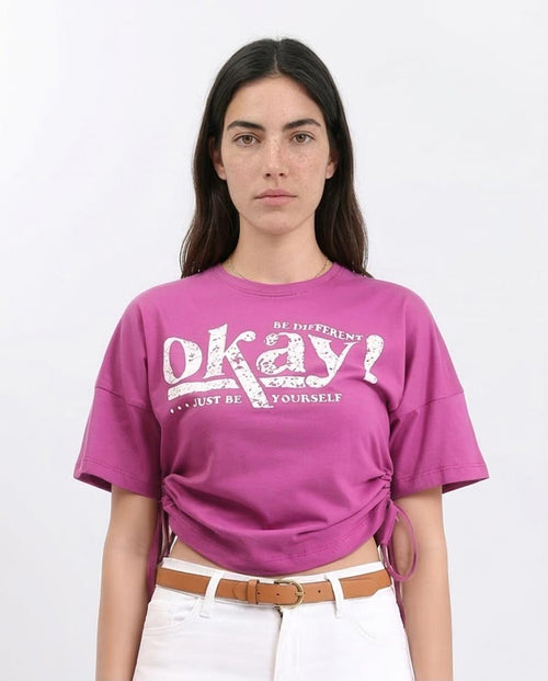 Woman wearing a pink t-shirt with a motivational quote on a white background
