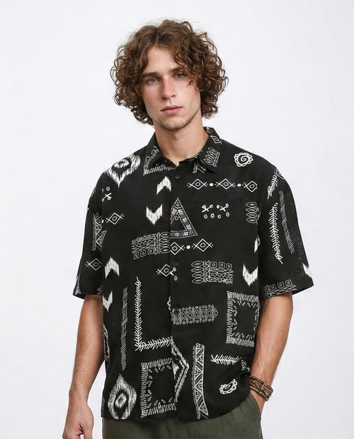 Man wearing a black patterned shirt on a white background