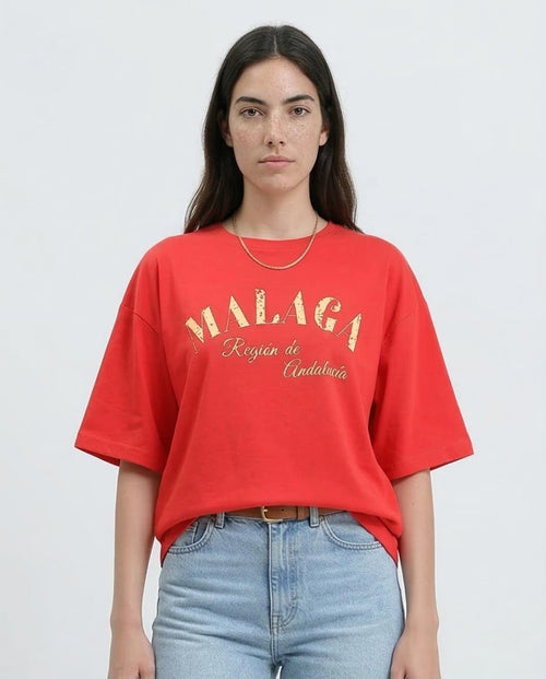 Woman wearing a red t-shirt with 'MALAGA' text on a plain background