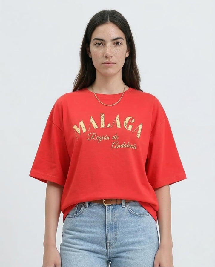 Woman wearing a red t-shirt with 'MALAGA' text on a plain background