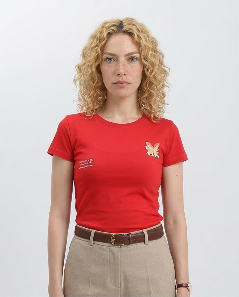 Woman wearing a red t-shirt with a small graphic and text on a plain background