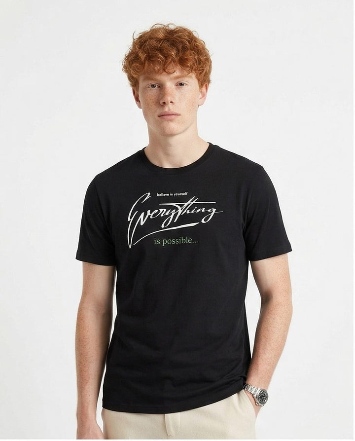 Man wearing a black t-shirt with 'Everything is possible' text on a white background