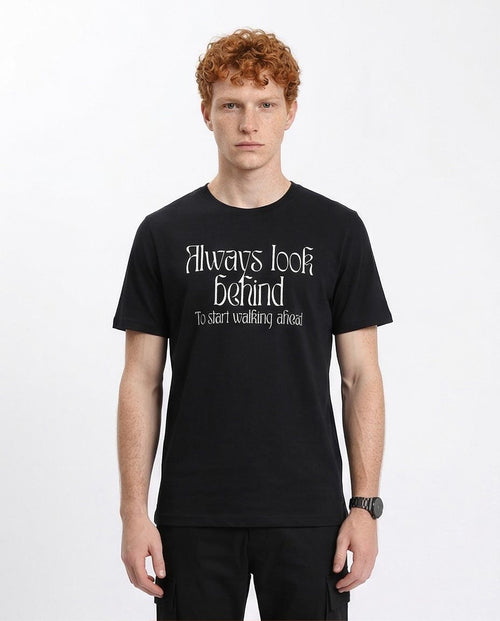 Man wearing a black t-shirt with text on a white background