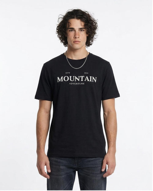 Man wearing a black t-shirt with 'Mountain Adventure' text on a white background