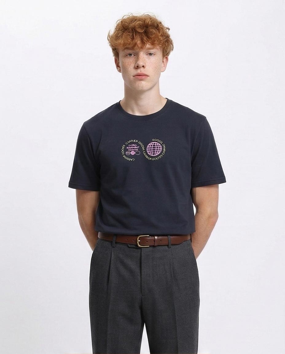 Man wearing a navy blue t-shirt with a logo and dark gray pants on a white background