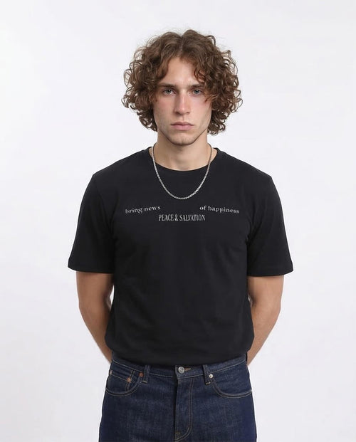 Person wearing a black t-shirt with text on a white background