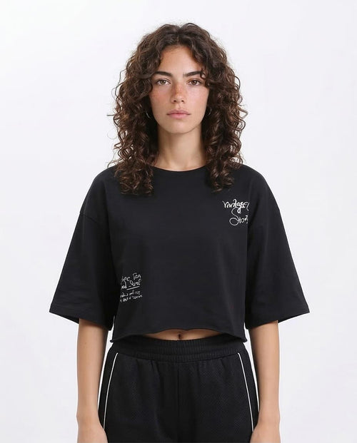 Woman wearing a black oversized t-shirt with text on a white background