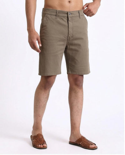 Person wearing beige shorts on a white background