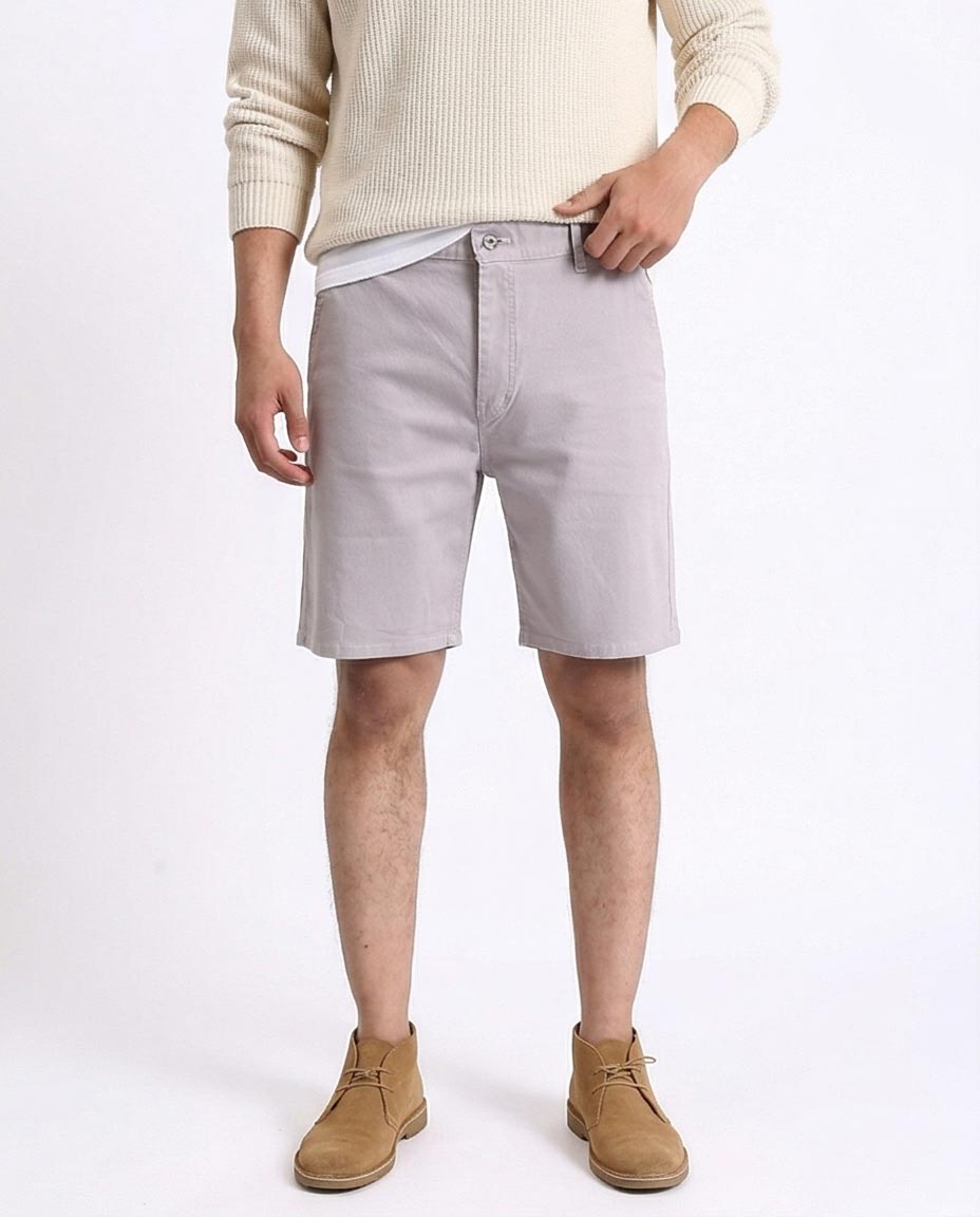 man wearing light gray shorts with a white background