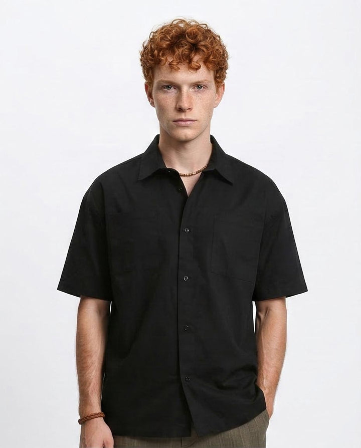 Man wearing a black short-sleeve shirt on a white background