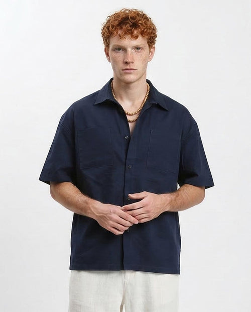 Man wearing a navy blue short-sleeve shirt on a white background