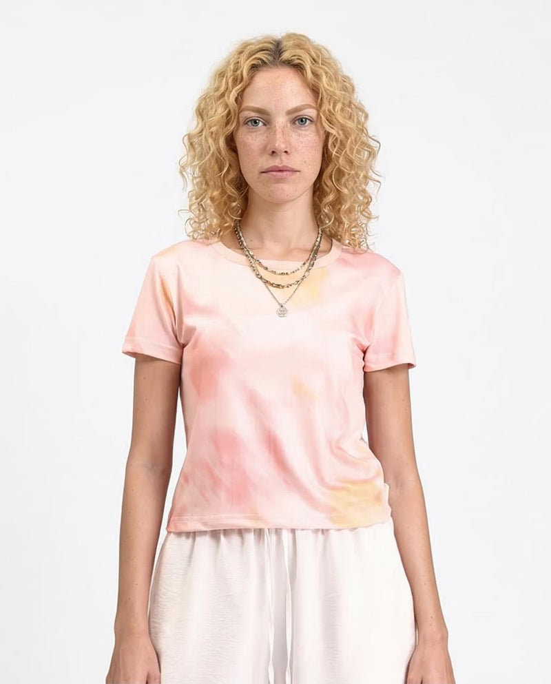 Woman wearing a tie-dye t-shirt with a plain background