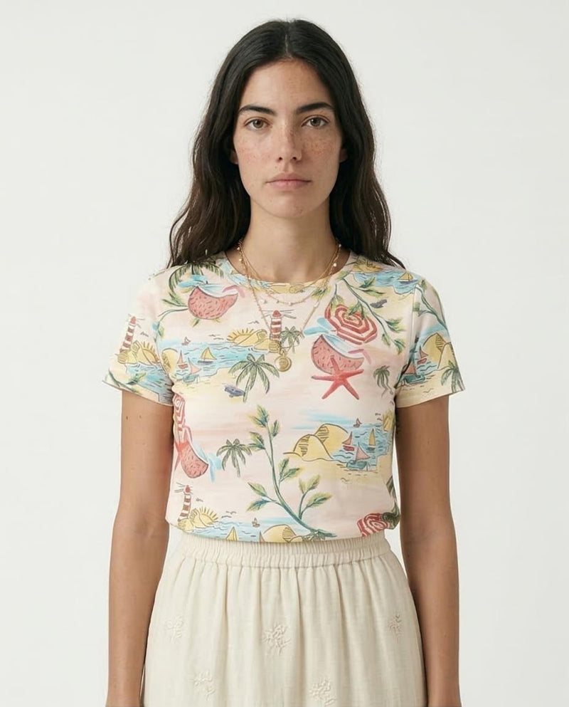 Woman wearing a colorful tropical-themed shirt with a plain background