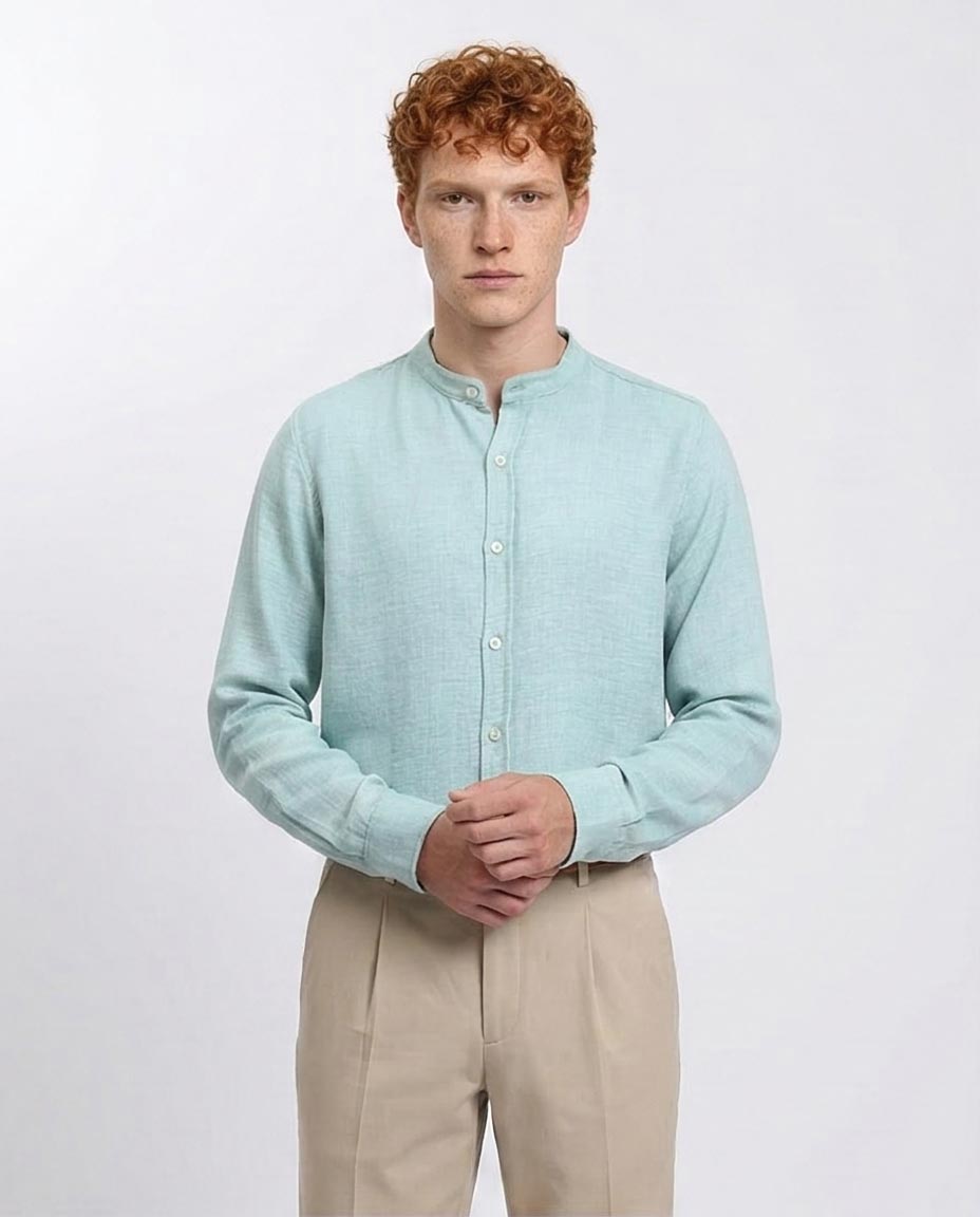 Man wearing a light blue shirt and beige pants against a white background