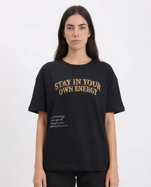Person wearing a black t-shirt with 'Stay in your own energy' text on a white background
