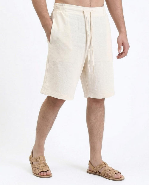 Man wearing beige shorts on a white background