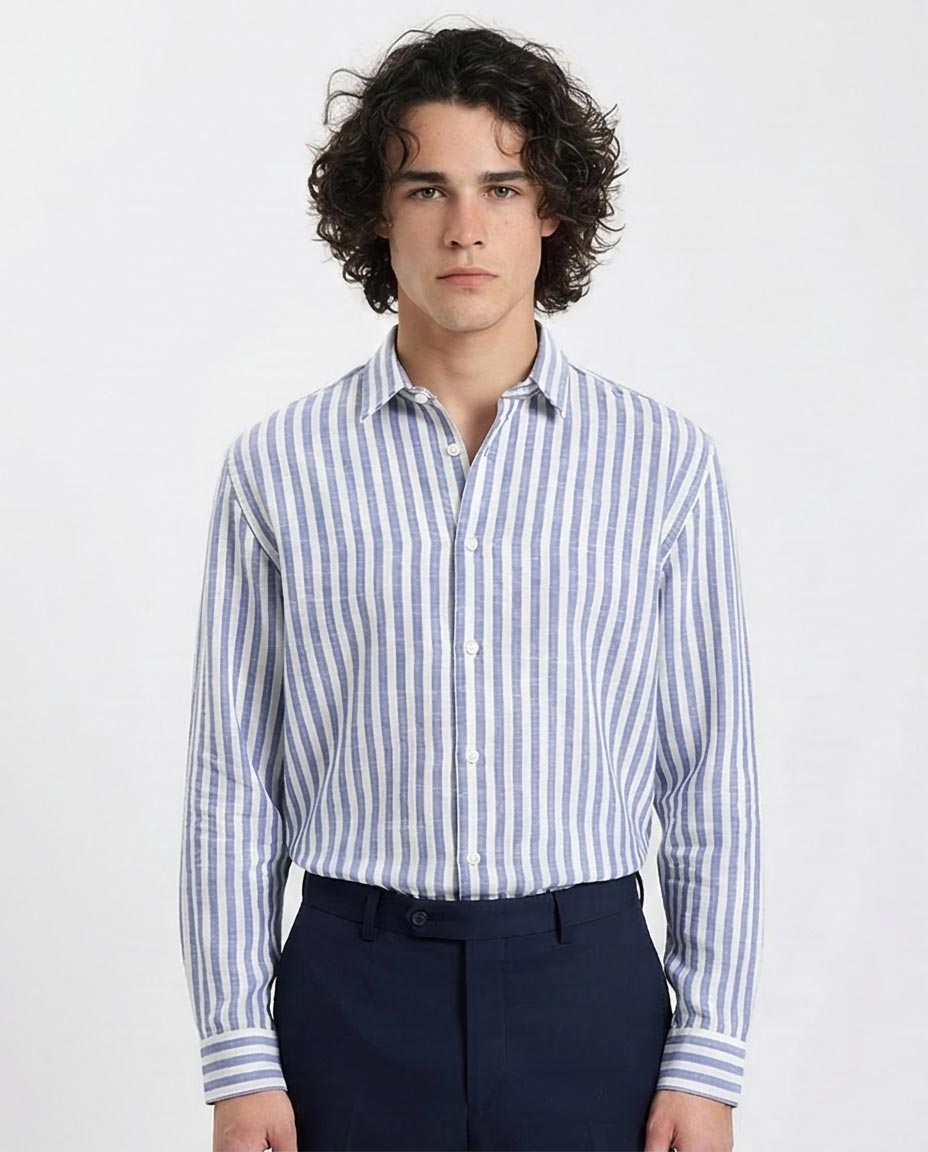 Man wearing a blue and white striped shirt with dark pants on a light gray background