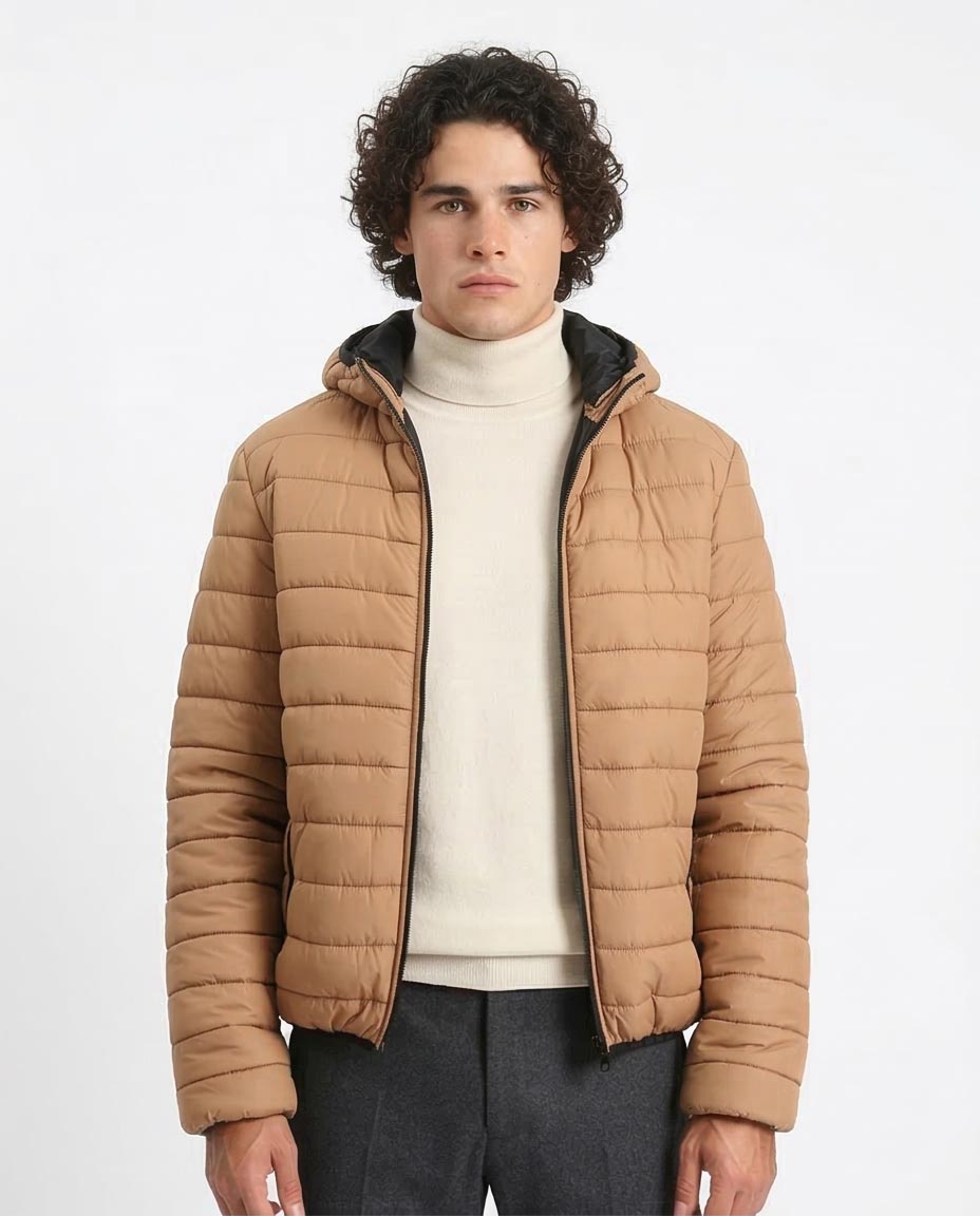 Man wearing a brown puffer jacket over a white sweater on a white background