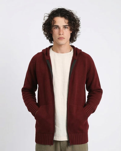 Man wearing a maroon hoodie over a white shirt on a white background