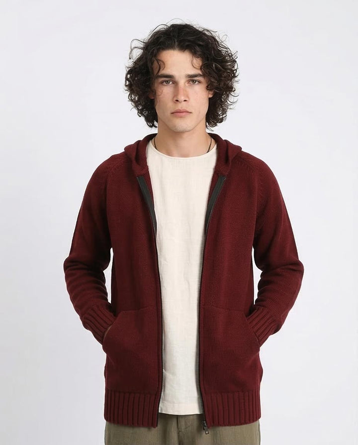 Man wearing a maroon hoodie over a white shirt on a white background